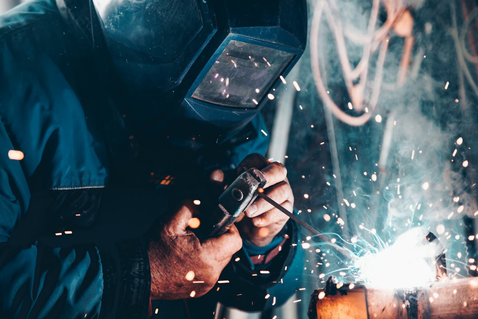 Trabajador industrial con equipo de proteccion realizando soldadura